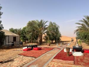 un complexe au milieu d'un désert planté de palmiers dans l'établissement Luxury traditional Tent Camp, à Merzouga