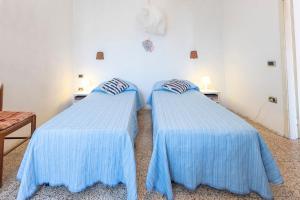 2 camas en una habitación con sábanas azules en Heart House Maremma, en Farnese