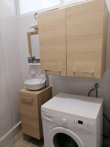 uma máquina de lavar roupa na casa de banho com um lavatório em Maison de pecheur cour privée en centre ville em Saint-Gilles-Croix-de-Vie
