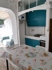 uma cozinha com mesa e cadeiras e uma cozinha com armários azuis em Maison de pecheur cour privée en centre ville em Saint-Gilles-Croix-de-Vie