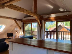 una sala de estar con una gran mesa de madera y ventanas en Top floor duplex with private beach en Duingt