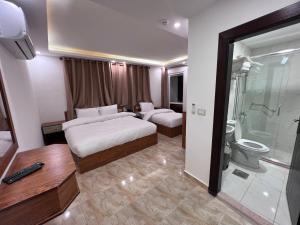 una camera d'albergo con due letti e un bagno di Petra Family Hotel a Wadi Musa