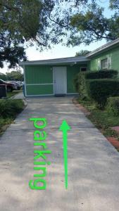 a driveway with a green arrow pointing to a house at Green house in Tampa