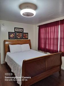 a bedroom with a bed and a red curtain at Green house in Tampa