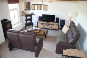 sala de estar con sofá y TV en Charmante maison de campagne "Chemin Saint-Roch", 