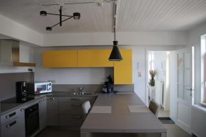 una cocina con armarios amarillos y blancos y fregadero en Charmante maison de campagne "Chemin Saint-Roch", 
