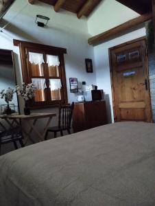 a bedroom with a bed and a table and a door at ROSINA HOUSE e CHALET in Colico