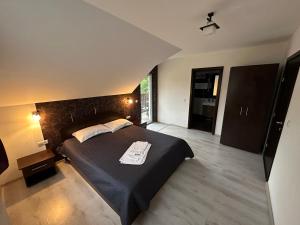 a bedroom with a large black bed in a room at Vila Eduard in Fundata
