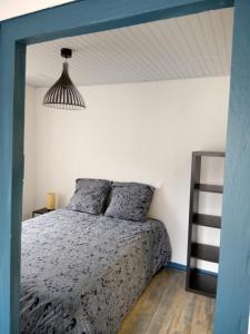 Dormitorio con cama con marco azul y escalera en Le JOËL appartement F1 de 21 m², en Choisey