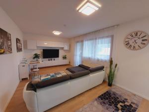 a living room with a couch and a clock on the wall at Apartement König in Lauf