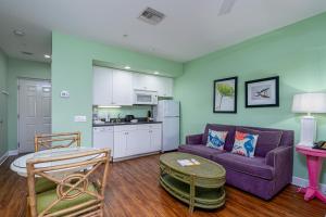 a living room with a purple couch and a kitchen at Harbour House at the Inn 310 in Fort Myers Beach