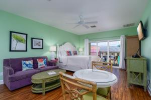 a living room with a purple couch and a bed at Harbour House at the Inn 310 in Fort Myers Beach
