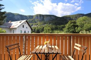 une table en bois et deux chaises sur une terrasse en bois dans l'établissement Apartments pr' Špeli, à Bohinj