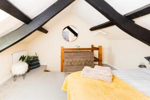 a attic bedroom with a bed and a window at Why Not in Stow on the Wold