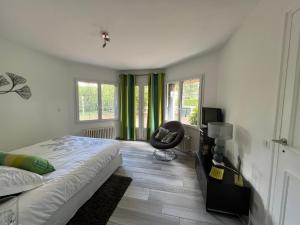 una camera da letto con un letto e una sedia di Chambre privée Chiberta a Chanas