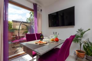 a dining room with a table and purple chairs at Magic holiday Apartment in Bale