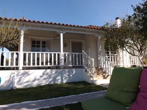 a house with a white fence and a porch at A&V's Home in Áyioi Apóstoloi