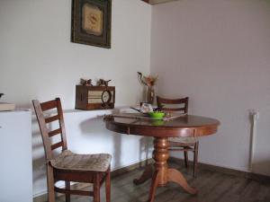 a dining room table with two chairs and a table with a bowl on it at Apartman Boljević in Podgorica