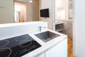 uma cozinha com um lavatório e uma televisão em Brera Livings, Charming flat near Duomo em Milão