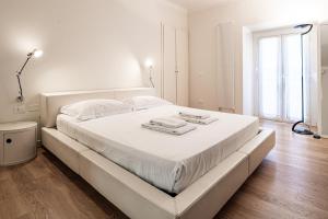 um quarto branco com uma cama grande e lençóis brancos em Brera Livings, Charming flat near Duomo em Milão