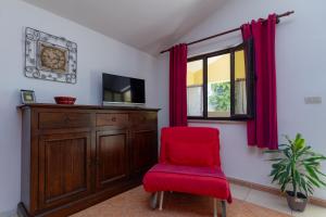 a red chair in a room with a window at Apartment Red Romantic 2-1 in Bale