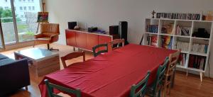 salon z czerwonym stołem i krzesłami w obiekcie Chambre chez l'habitant a 5 minutes du métro w mieście Ivry-sur-Seine