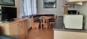 eine Küche mit einer Theke und einem Tisch mit einem TV in der Unterkunft Studio B14 in Schladming