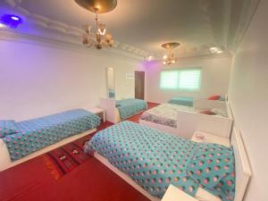 Zimmer mit 3 Betten und einem Spiegel in der Unterkunft Jordan Guest House in Wadi Musa