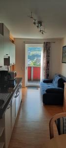 ein Wohnzimmer mit einem Sofa und eine Küche mit einem Fenster in der Unterkunft Studio B14 in Schladming