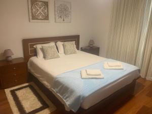 a bedroom with a bed with two towels on it at Luis Place Machico LifeStyle in Machico