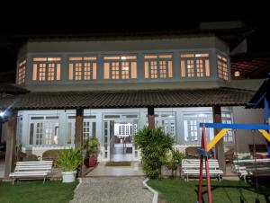 a large house with benches in front of it at night at Hotel Nova Guarapari in Guarapari