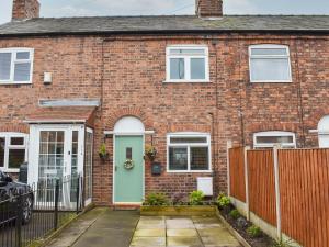 a brick house with a green door at Gavels Gap in Nantwich