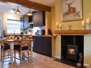 a kitchen with a table and a fireplace at Gavels Gap in Nantwich