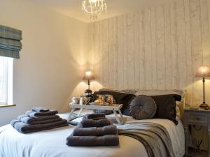 a bedroom with a bed with towels on it at Gavels Gap in Nantwich