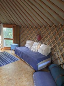 a bedroom with a bed in a yurt at La yourte au fonds du jardin in Xhoris