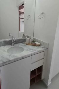 een badkamer met een wastafel en een spiegel bij Loft - Condomínio da Fé - Canção Nova in Cachoeira Paulista