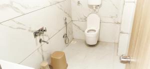 a white bathroom with a toilet and a sink at Hotel 9 Coin in Shirdi