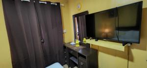 a bathroom with a large television and a black curtain at Marhaba Homes Gensan in General Santos