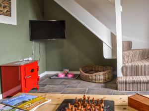 a living room with a table and a tv at Fox Cottage in Henstead