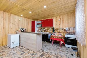 a kitchen with red cabinets and a counter with a table at Guest House Nazo in Omalo