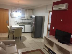 a living room with a kitchen with a refrigerator at ÁGUAS DA SERRA- Rio Quente-GO APTO 2 Qtos particular- in Rio Quente