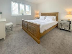 a bedroom with a large bed and two night stands at Little Crickets in Felpham
