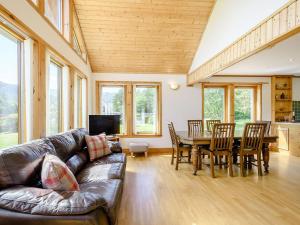 a living room with a leather couch and a table and chairs at Benmore Drimfern - Uk38742 in Benmore
