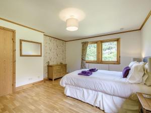 a bedroom with a large white bed and a window at Benmore Drimfern - Uk38742 in Benmore