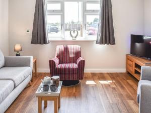 a living room with a couch and a chair and a tv at Park View in Martham