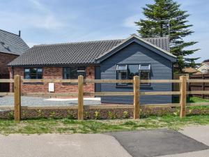a house with a wooden fence in front of it at Park View in Martham