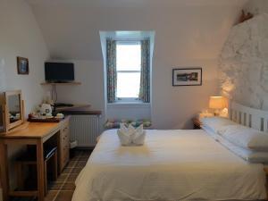 um quarto com uma cama, uma secretária e uma janela em Harbour view em Tobermory