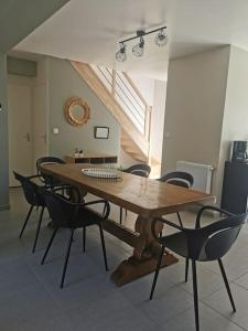 un tavolo e sedie in legno in una stanza di Maison cosy entre Paris Rouen et Deauville a Pont-de-lʼArche