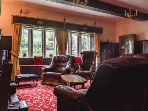 a living room with leather furniture and a couch at Foxstones Farm House in Worsthorne