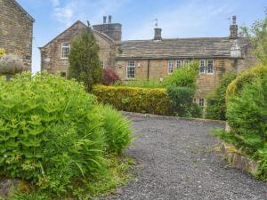 an old brick house with bushes in front of it at Foxstones Farm House in Worsthorne